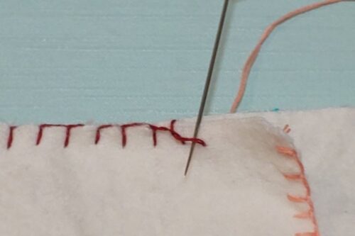 新しい糸を通した針を縫い終わりに緩めていた糸に通したところ