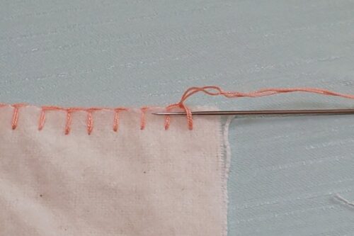 一枚の布でのブランケットステッチの終わり。最後の糸に横から針を通す