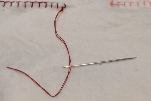 玉結びの下から出ている糸が針に通っている